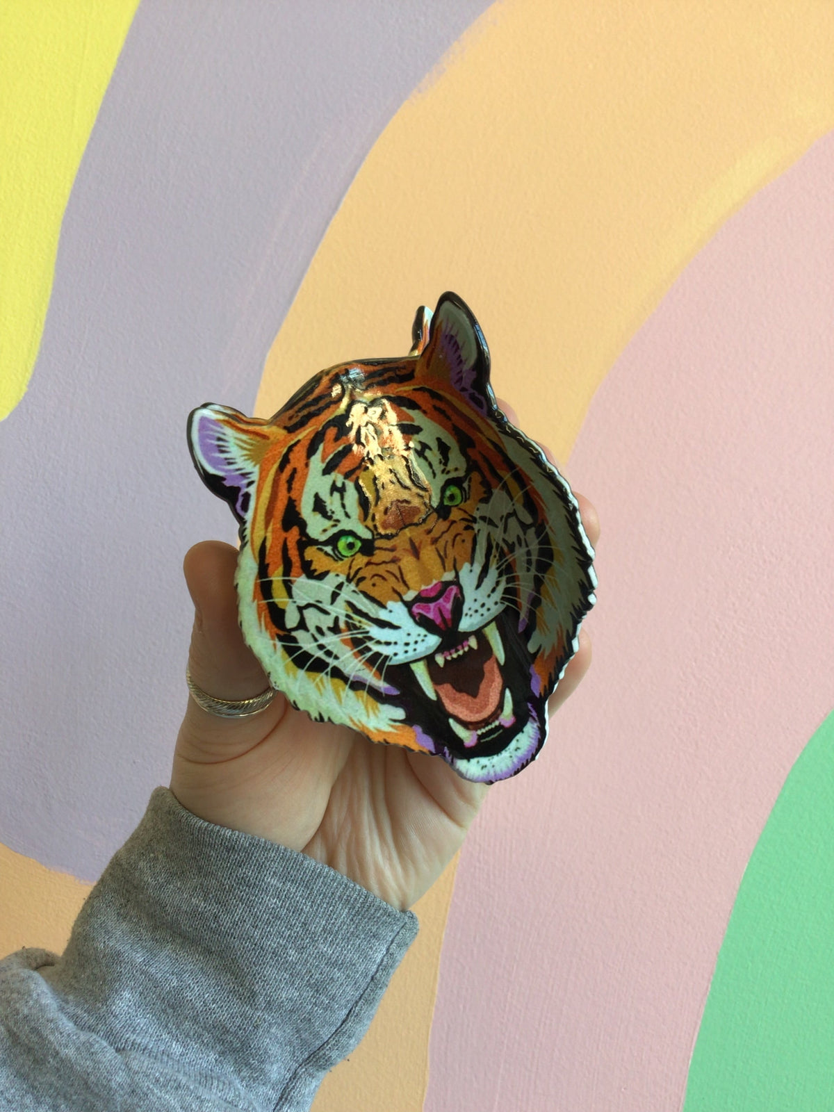 Tiger face hair claw with orange stripes, green eyes, and open-mouth expression