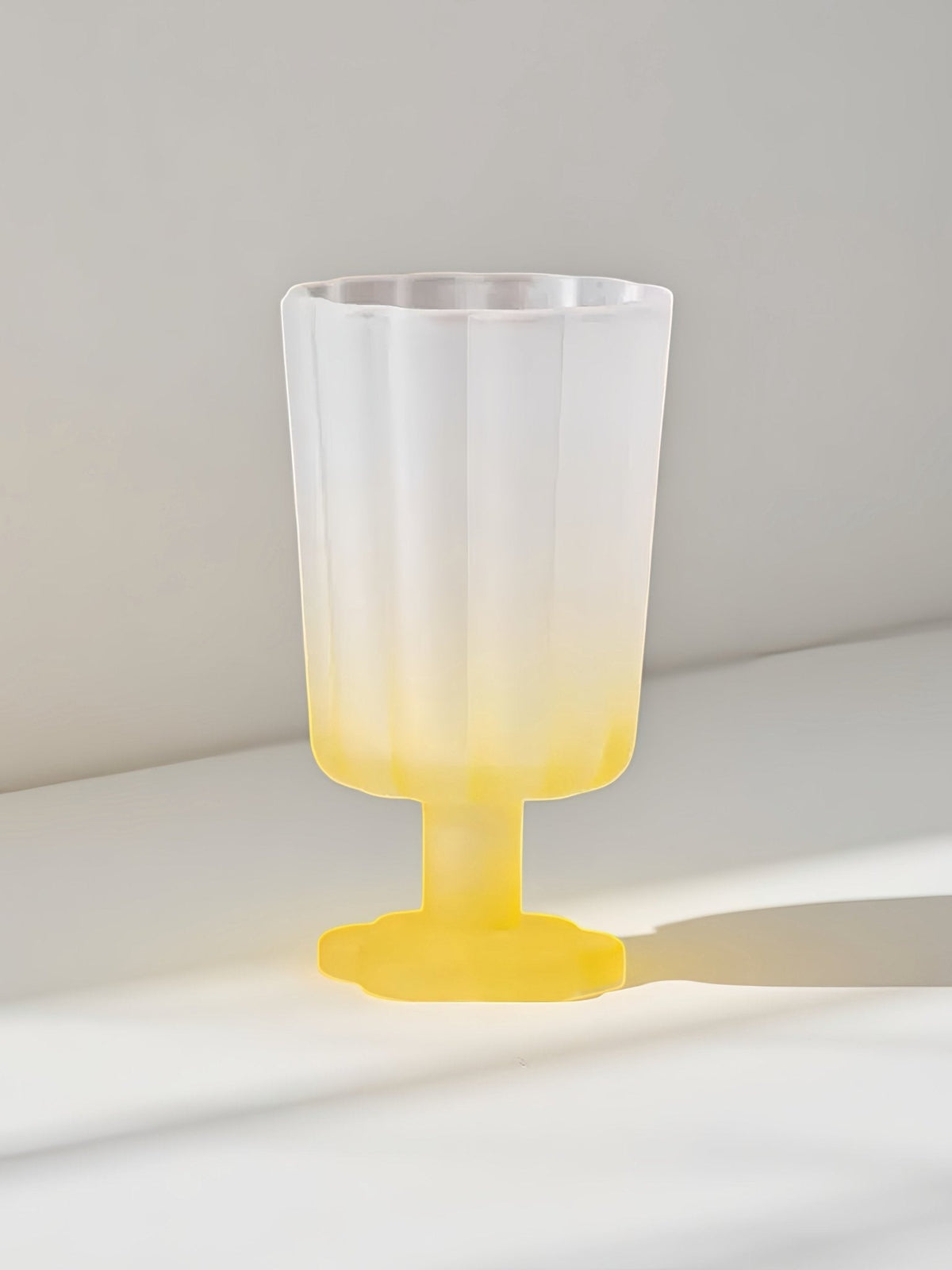 Hand-blown petal wine goblet with pale blue top and yellow base.