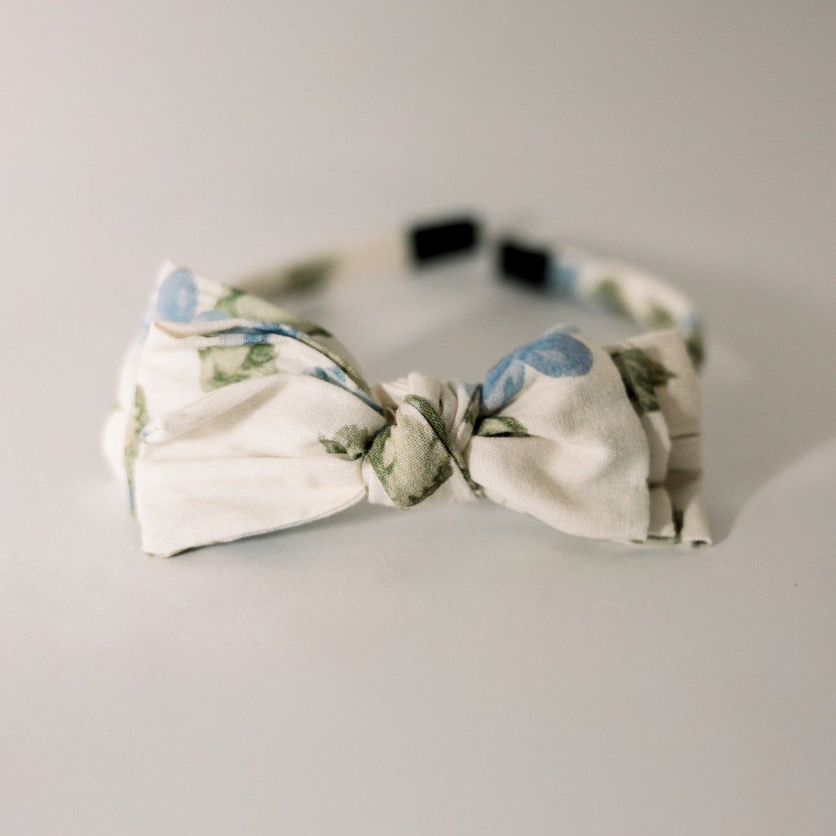 Three-bow headband in cream with cornflower blue polka-dot bow and greenery