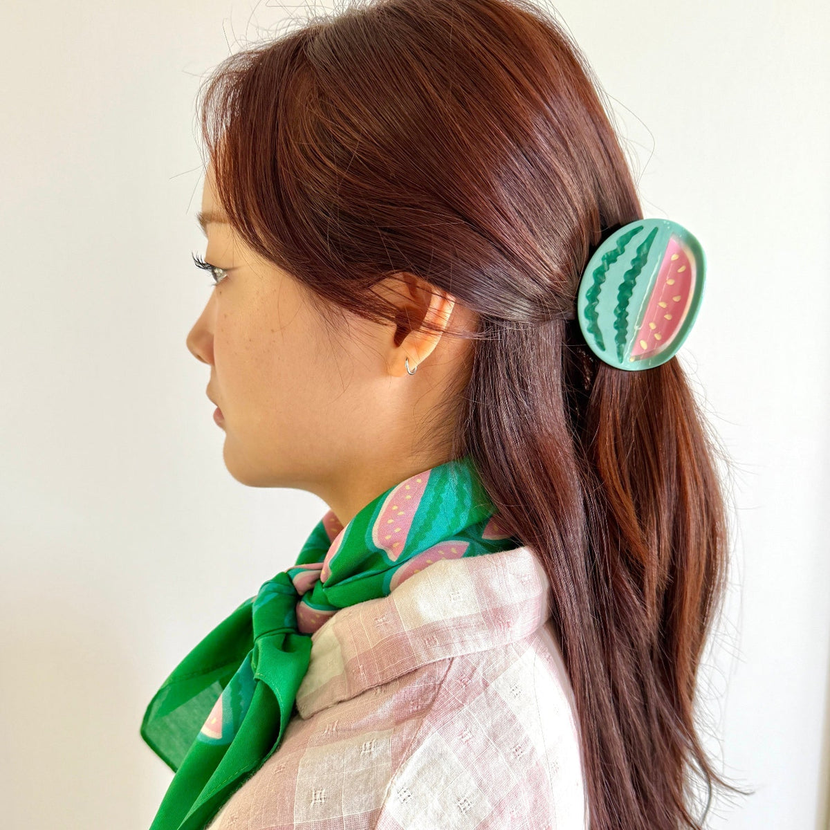 Watermelon hair claw clipped in long brown hair with teal and pink design