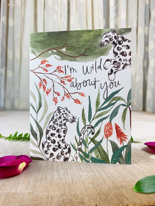 Jungle greeting card with kraft envelope, leopard print, tropical leaves, and 'I'm wild about you'.