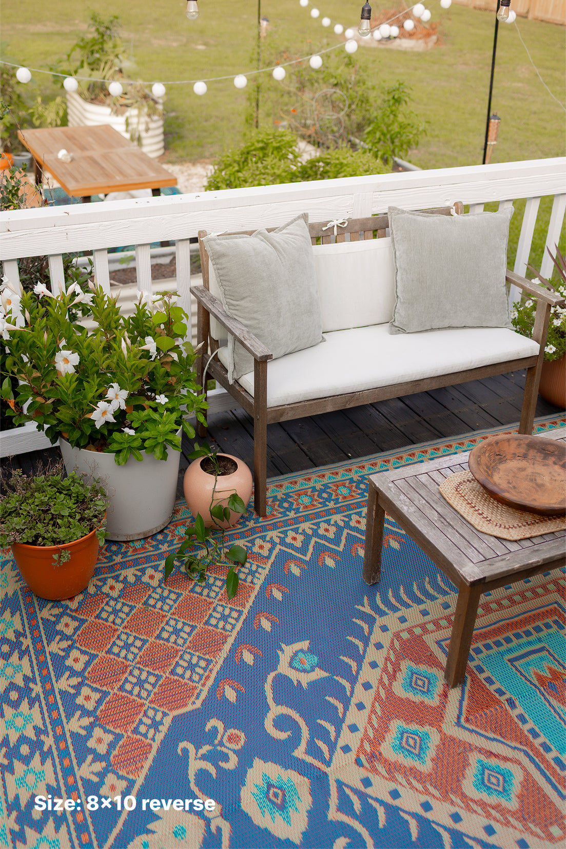 Turkish-style area rug on patio with blue and orange geometric motifs; Size 8x10 reverse