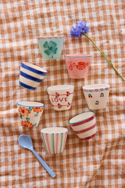 Set of ceramic espresso cups with pastel patterns, one with red 'LOVE' text