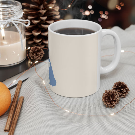Ceramic mug with blue silhouette design, filled with dark coffee, side view