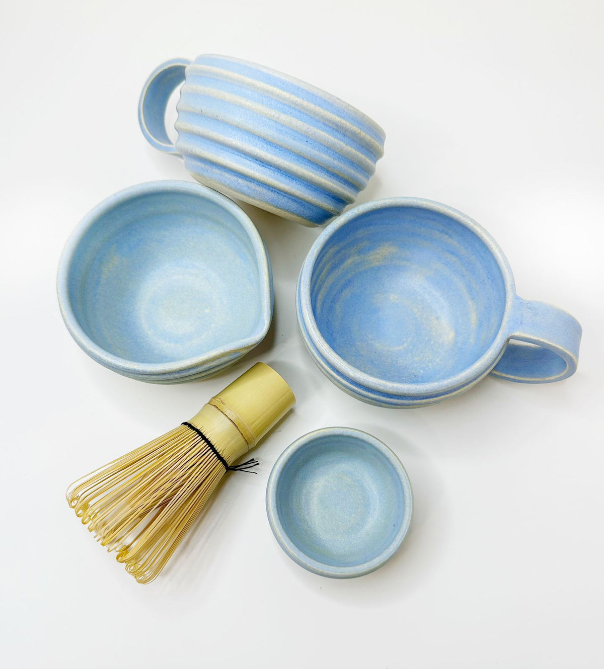 Blue matcha bowl set with multiple small bowls and bamboo whisk