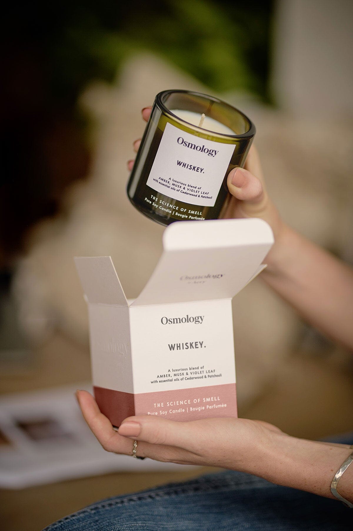 Scented candle jar held in hand with label, with white gift box