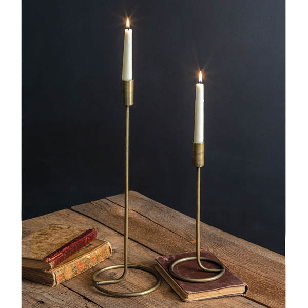 Pair of brass taper candle holders with round bases and slender stands