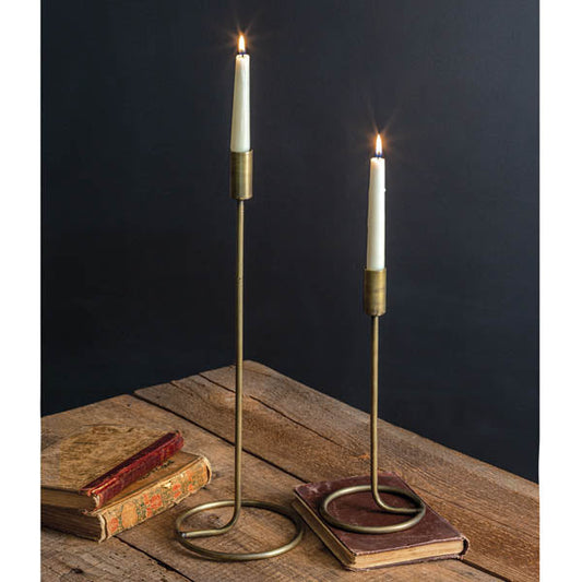 Pair of brass taper candle holders with round bases and slender stands