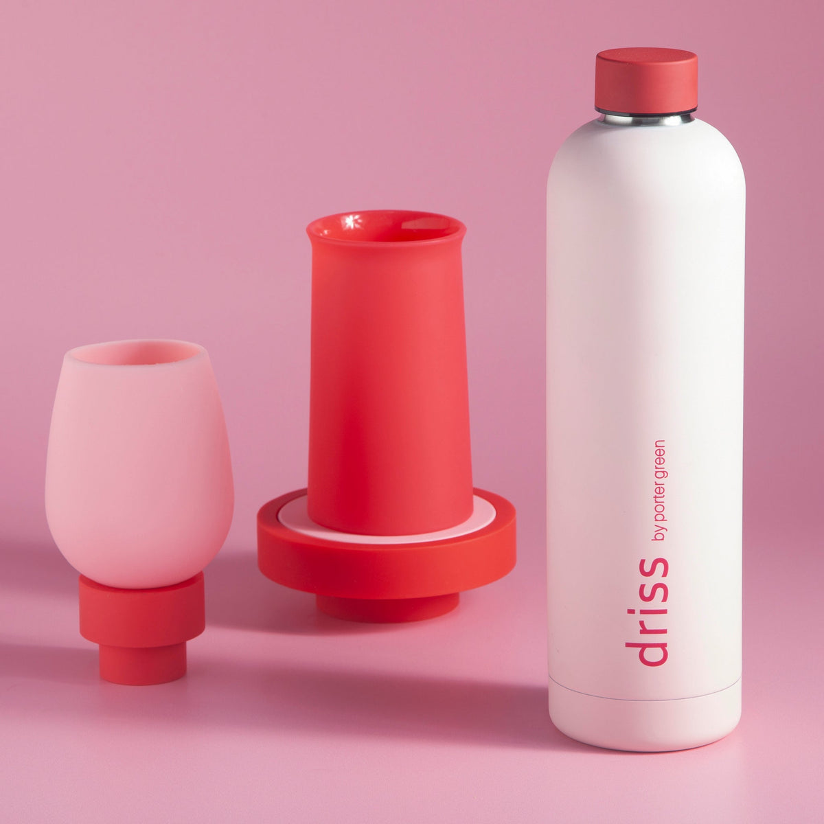 Silicone unbreakable glasses, blush and cherry red tulip cups, with white bottle nearby