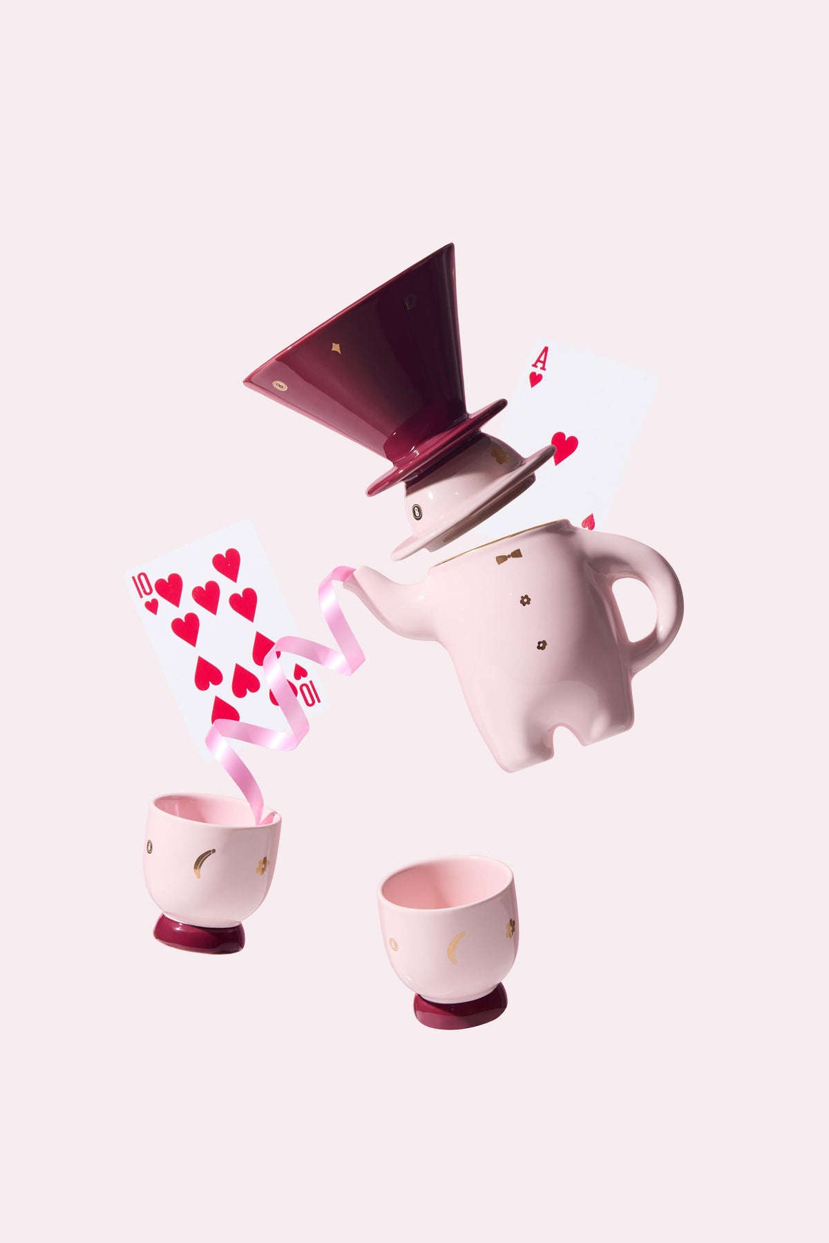 Pink porcelain teapot and cups with coffee dripper, spilling effects with hearts graphics