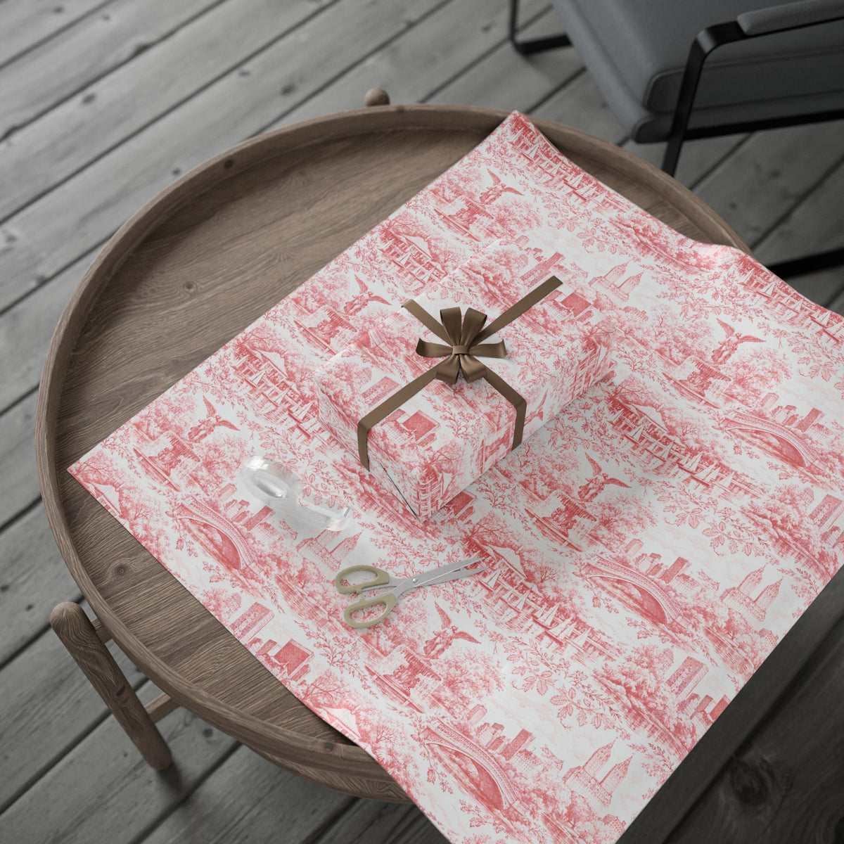 Red and white toile wrapping paper gift on wooden tray with ribbon bow