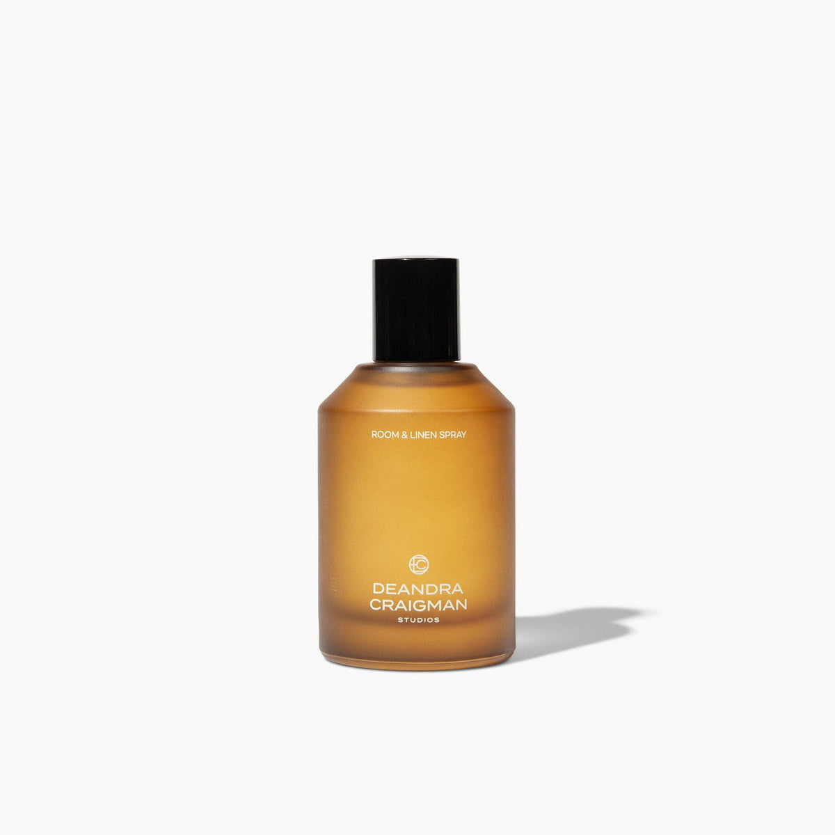 Amber room and linen spray bottle with black cap, front label visible