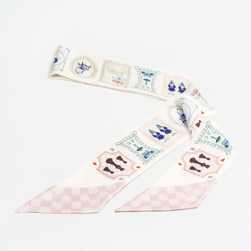 Silk twilly scarf shown unfolded: cream border with pale pink checker panels and card motifs