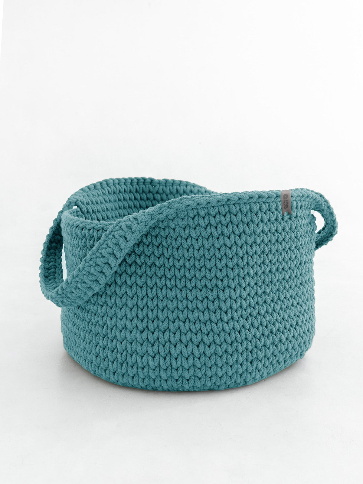 Round knitted storage basket with handles in teal blue, textured knit and stitched rim
