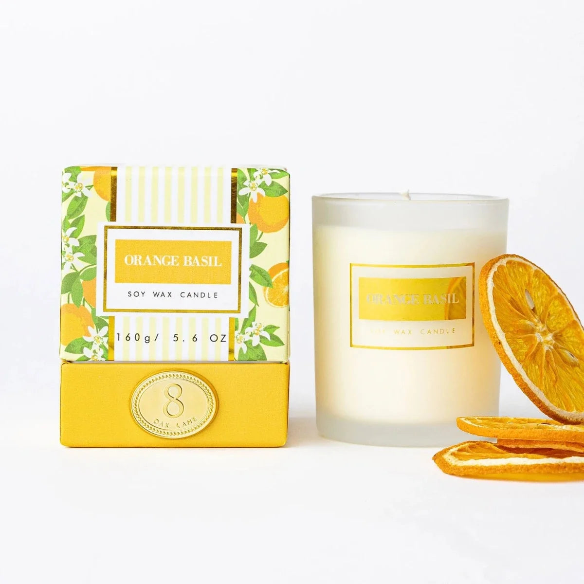 Boxed orange basil candle with white jar, gold label, and orange slice