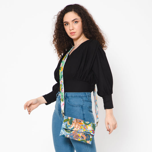 Floral embroidered crossbody strap holding a small multicolor pouch