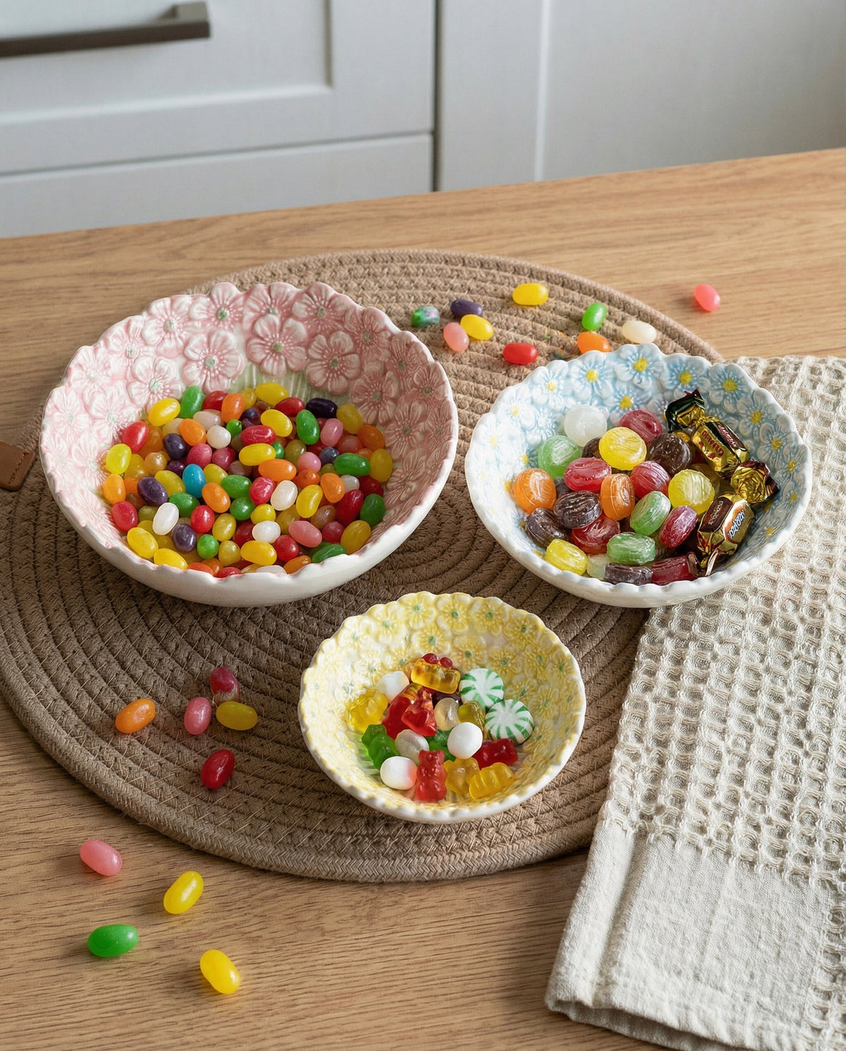 Embossed daisy ceramic bowls with ridged green fan center, filled with colorful candy