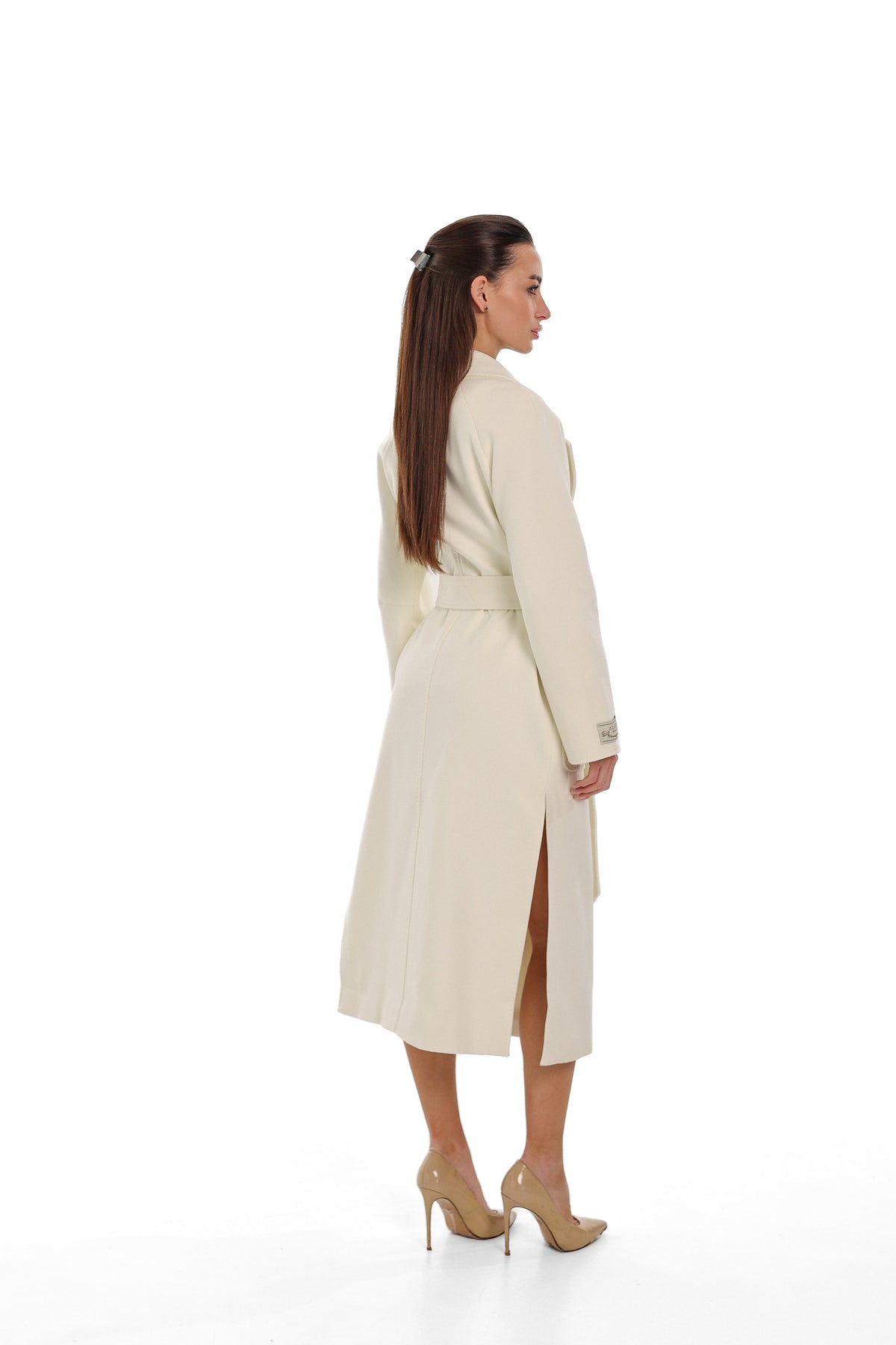 Back view of the ivory overcoat, showing its long cut and side slit