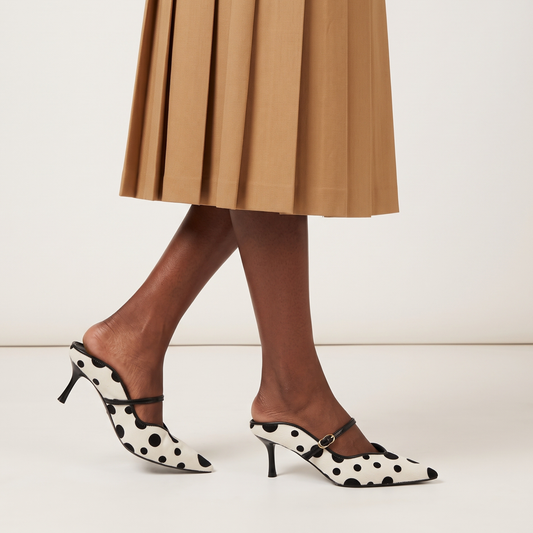 Polka-dot pony hair pumps with thin black ankle strap and pointed toe heel.