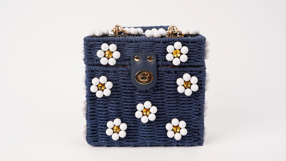Navy woven mini tote bag with white flower appliques and gold clasp front