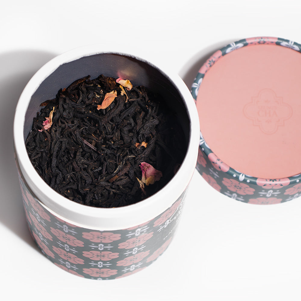 Opened tea tin showing dark loose black tea leaves