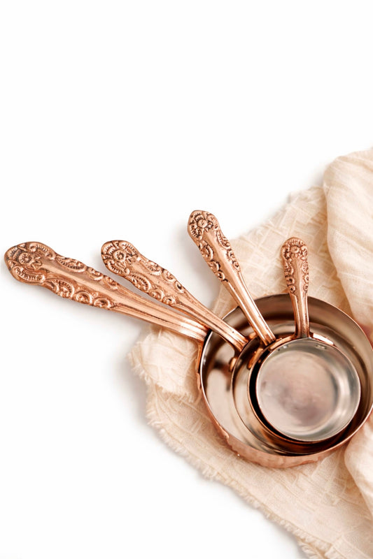 Copper measuring cups set with embossed handles and four small bowl measures