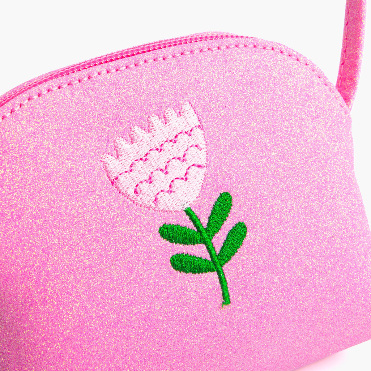 Close-up of pink glitter purse with embroidered flower