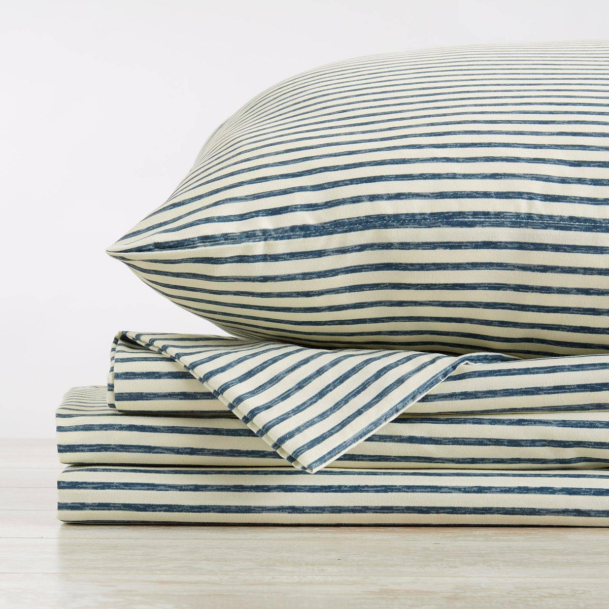 Blue striped microfiber sheet set with folded flat sheet and pillowcases stacked