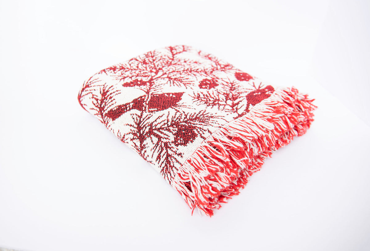 Folded throw blanket in cranberry red and cream jacquard with cardinal pattern and fringe