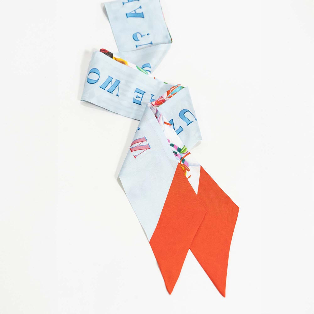 Silk twilly scarf with light blue illustrated pattern and orange-red pointed ends