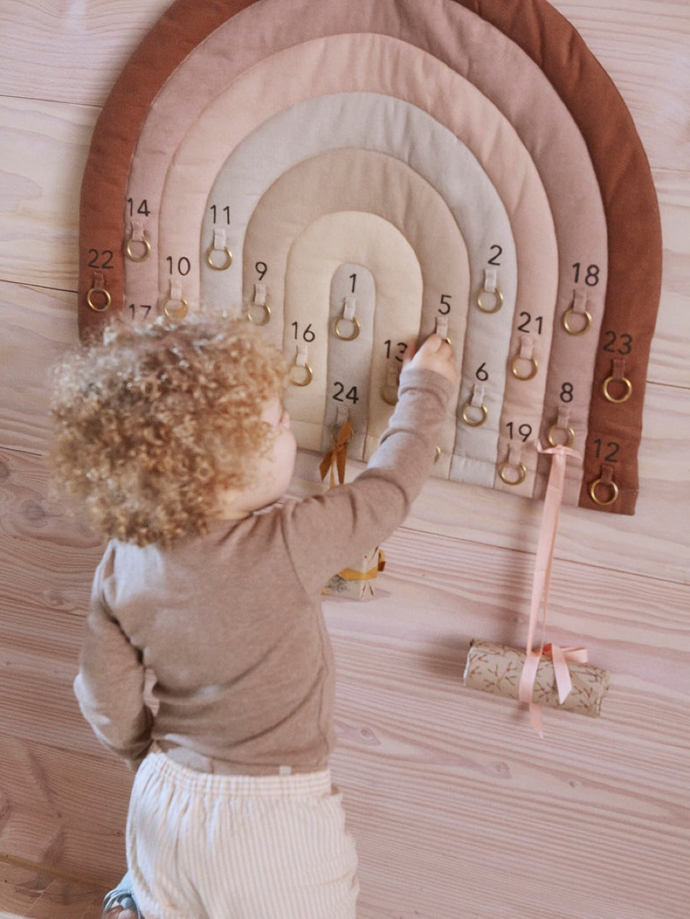 Rainbow arch advent calendar with numbered slots and hanging charms detail