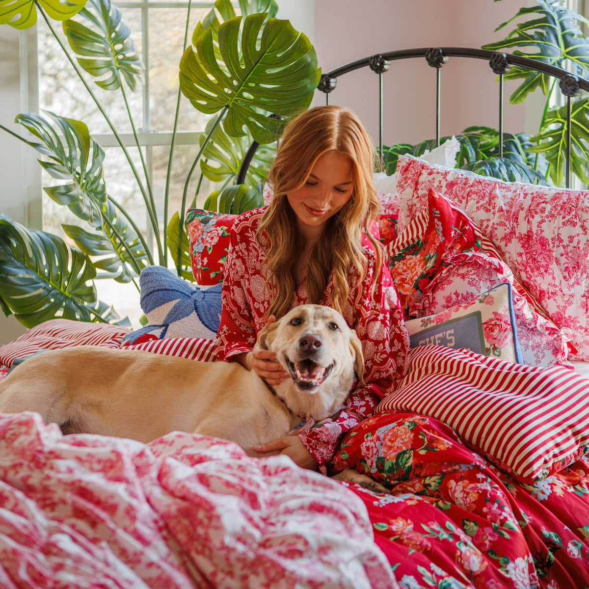 Embroidered decorative pillow on floral bedding with “She’s Whiskey in a Tea Cup”