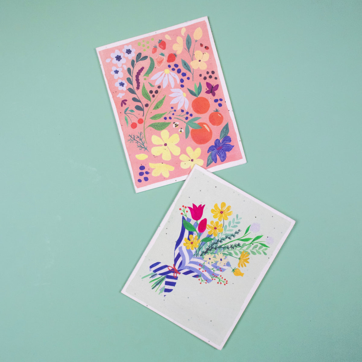 Floral seed cards, one pink and one white, with colorful plant illustrations and ribbon bows