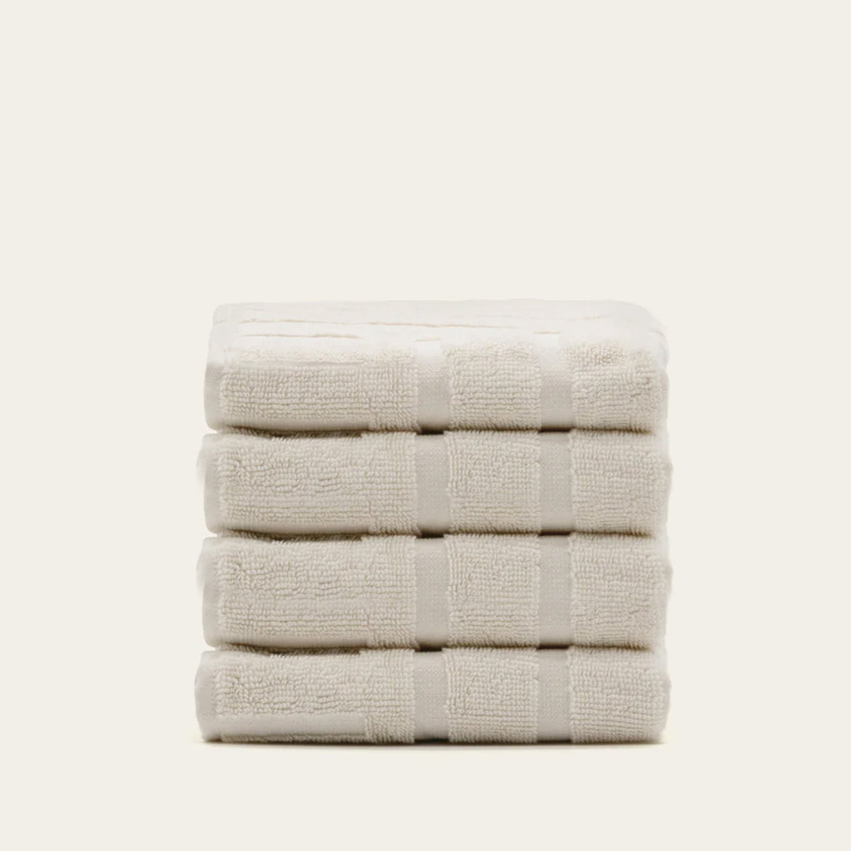 Folded light beige terry towels with horizontal stripe texture.
