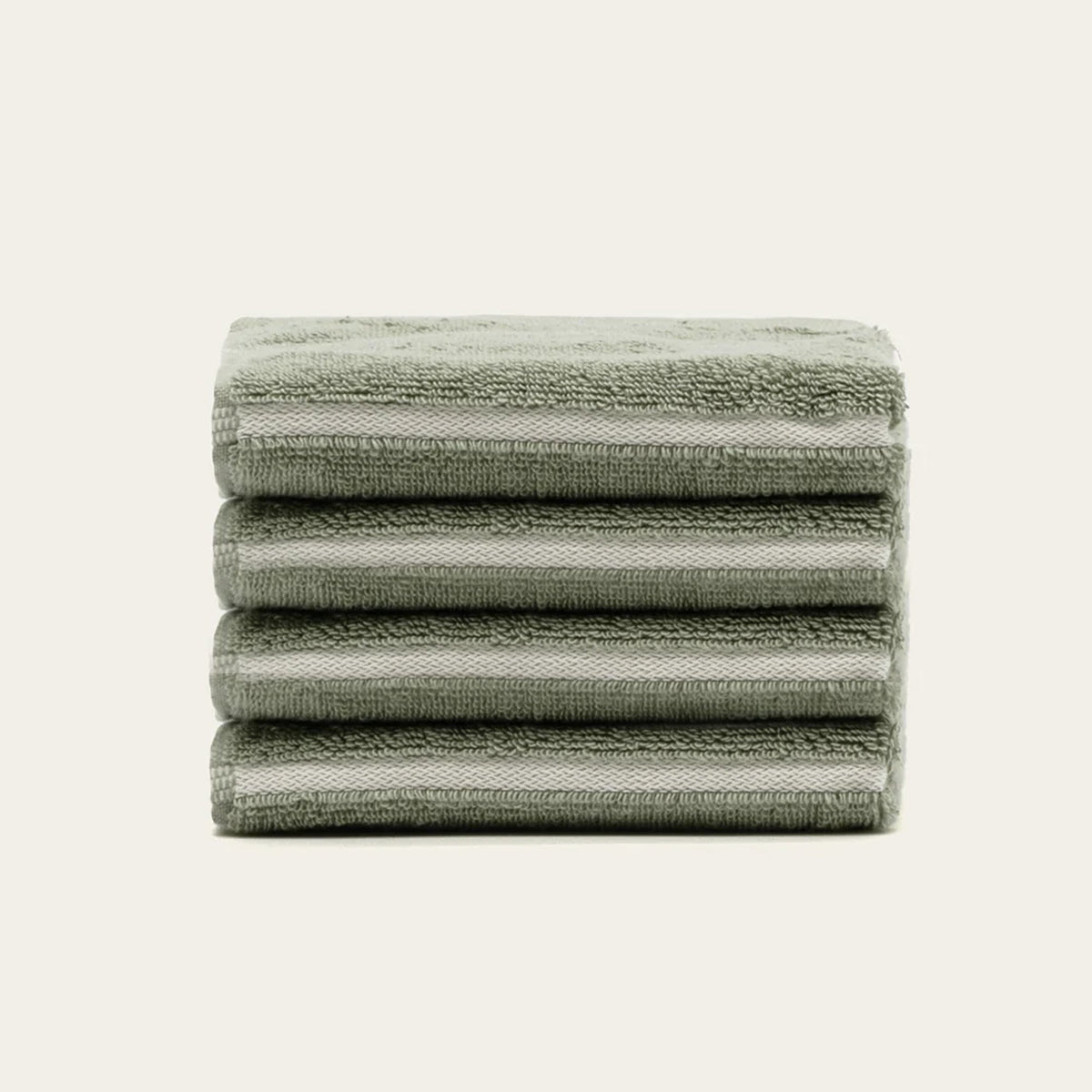 Sage green cotton towels, neatly stacked with ecru horizontal stripes