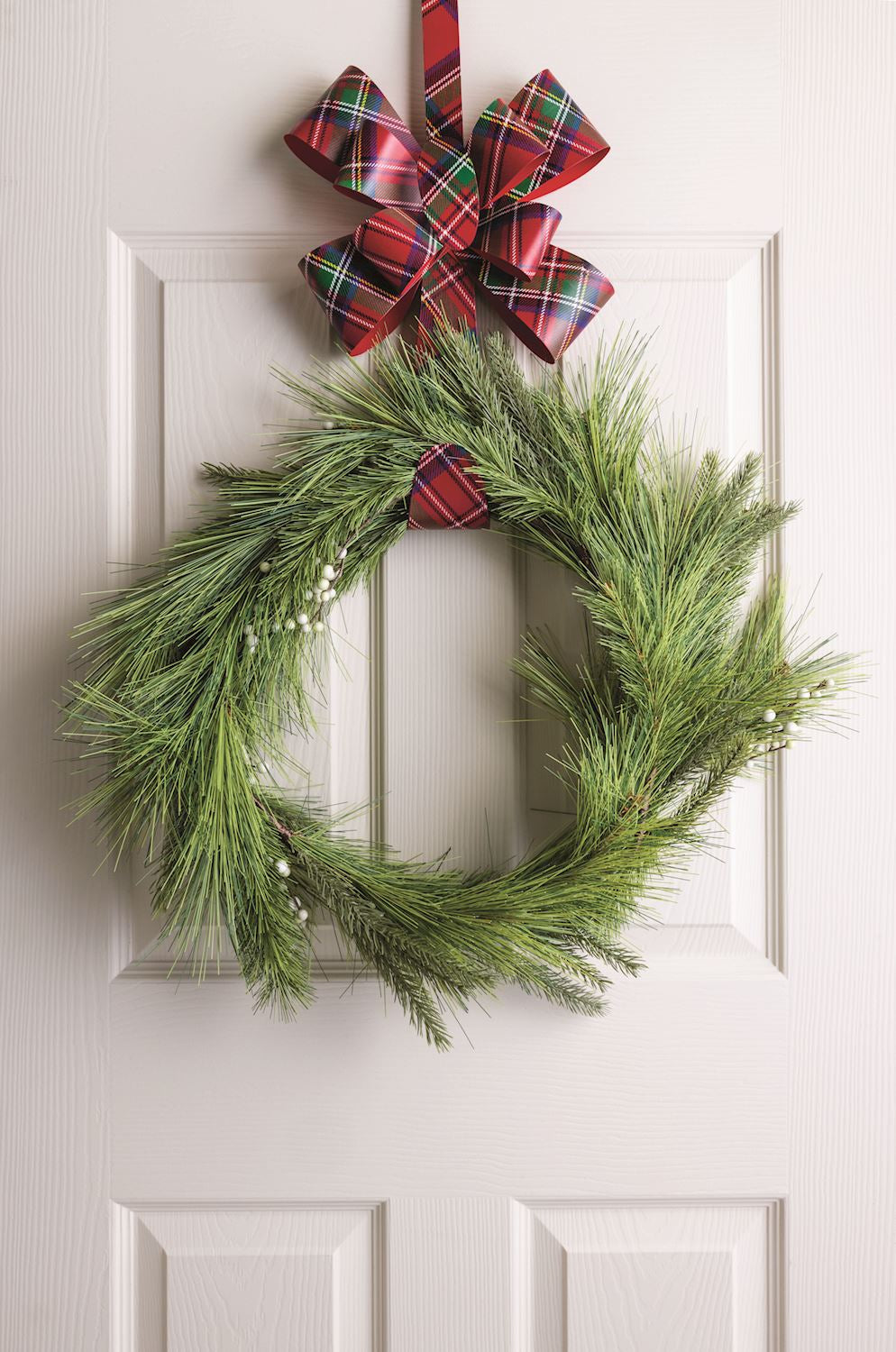 Metal wreath hanger with plaid bow and pine wreath ring