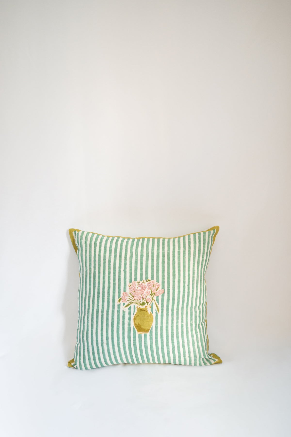 Square green striped throw pillow with floral bouquet applique in center and yellow trim