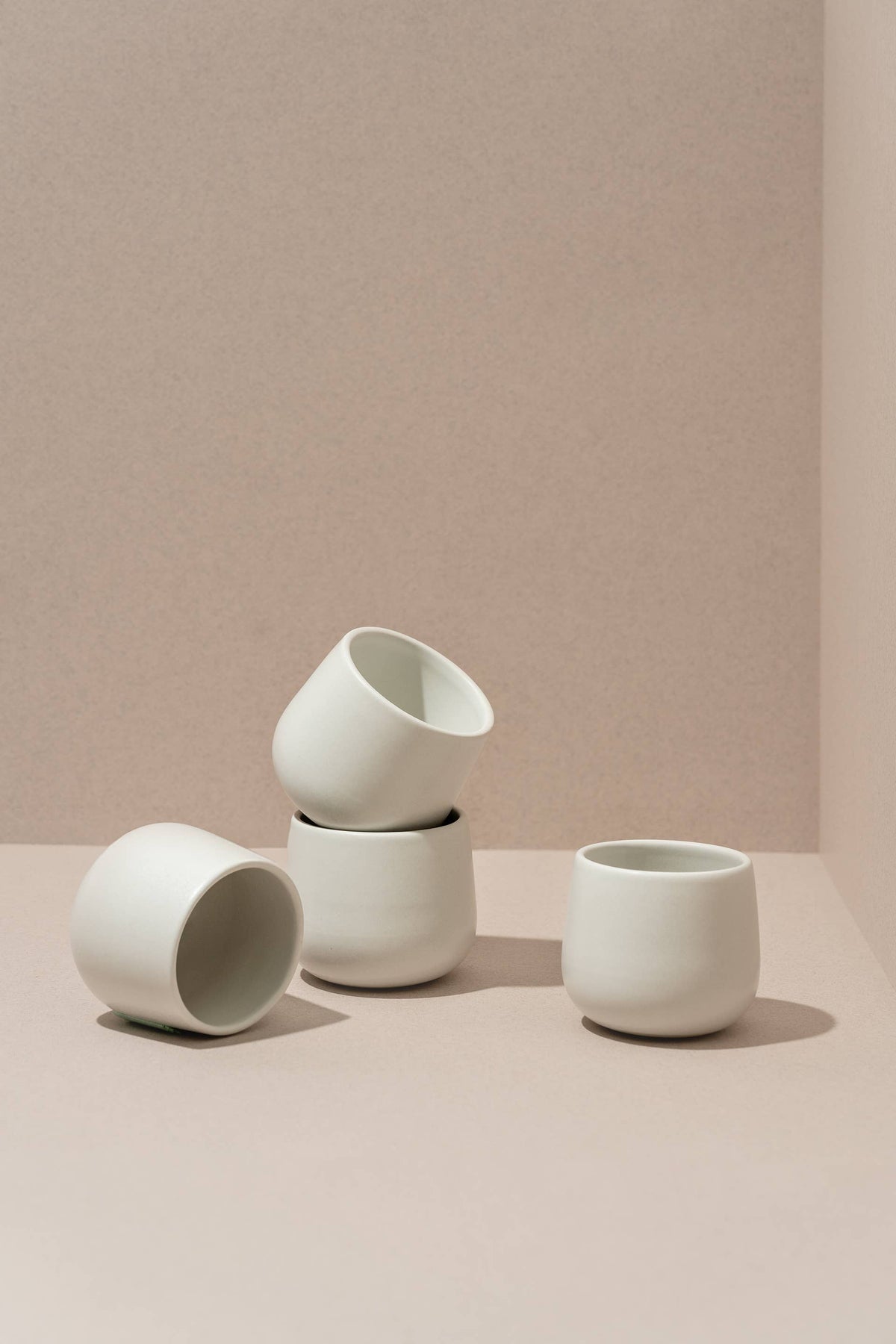 Matte white stoneware coffee cups, three small mugs with wide openings