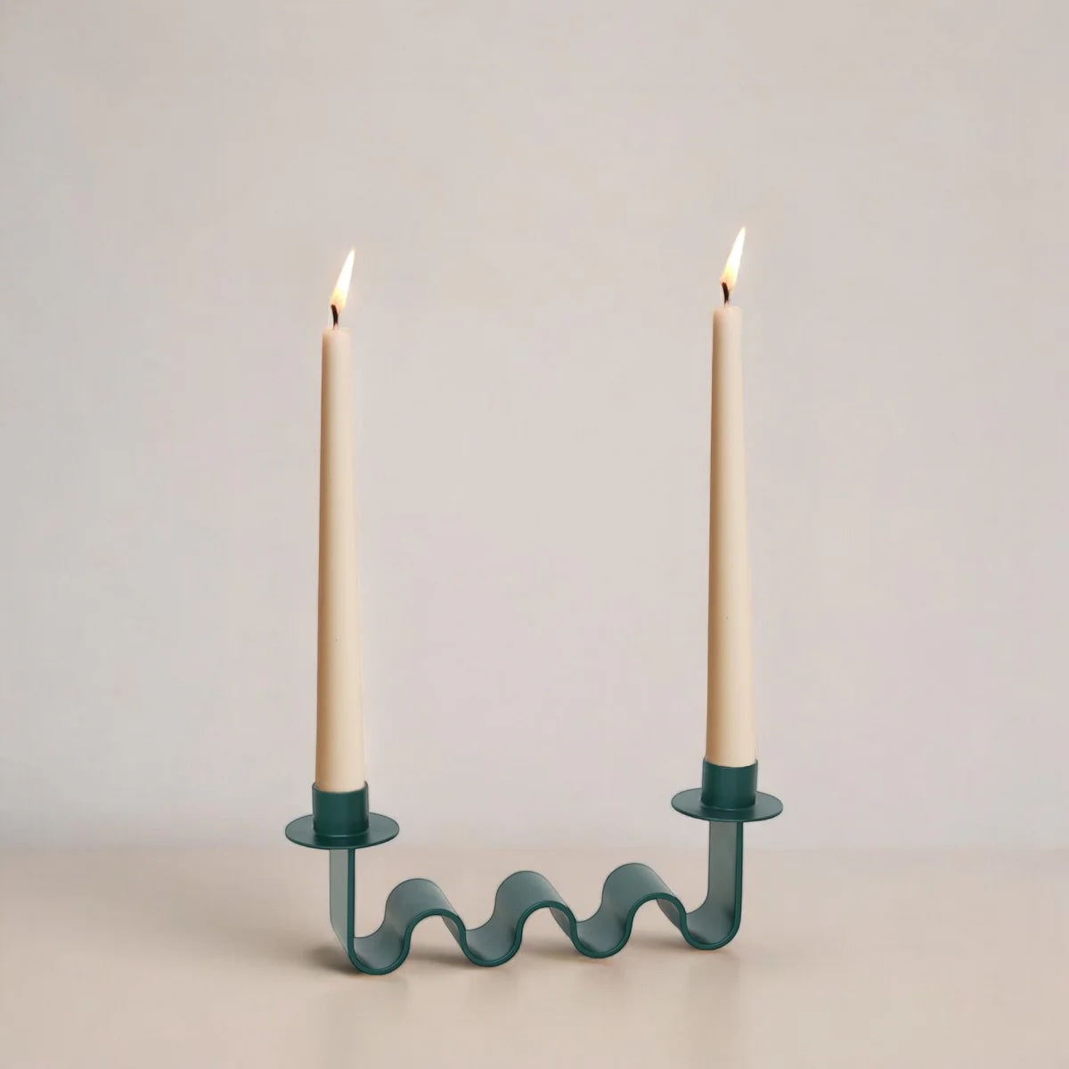 Forest green wavy candle holder with two holders, holding two cream candles