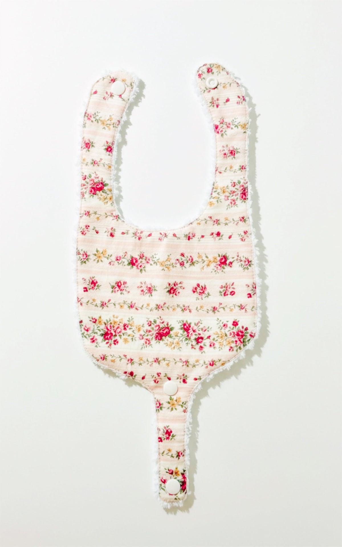 Soothe & Snap pacifier bib with red-pink floral print, horizontal bands, and snap center