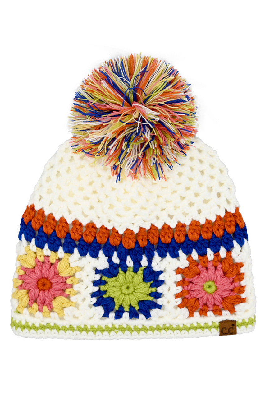 Handmade crochet beanie in white with rainbow pom-pom and colorful stripe flower motifs
