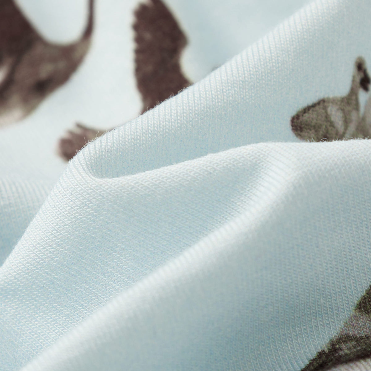 Light blue knit beanie hat fabric close-up with animal print