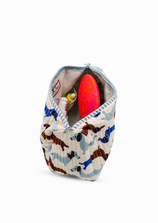 Dog-print toiletry bag with zip-open top, showing interior pockets and items