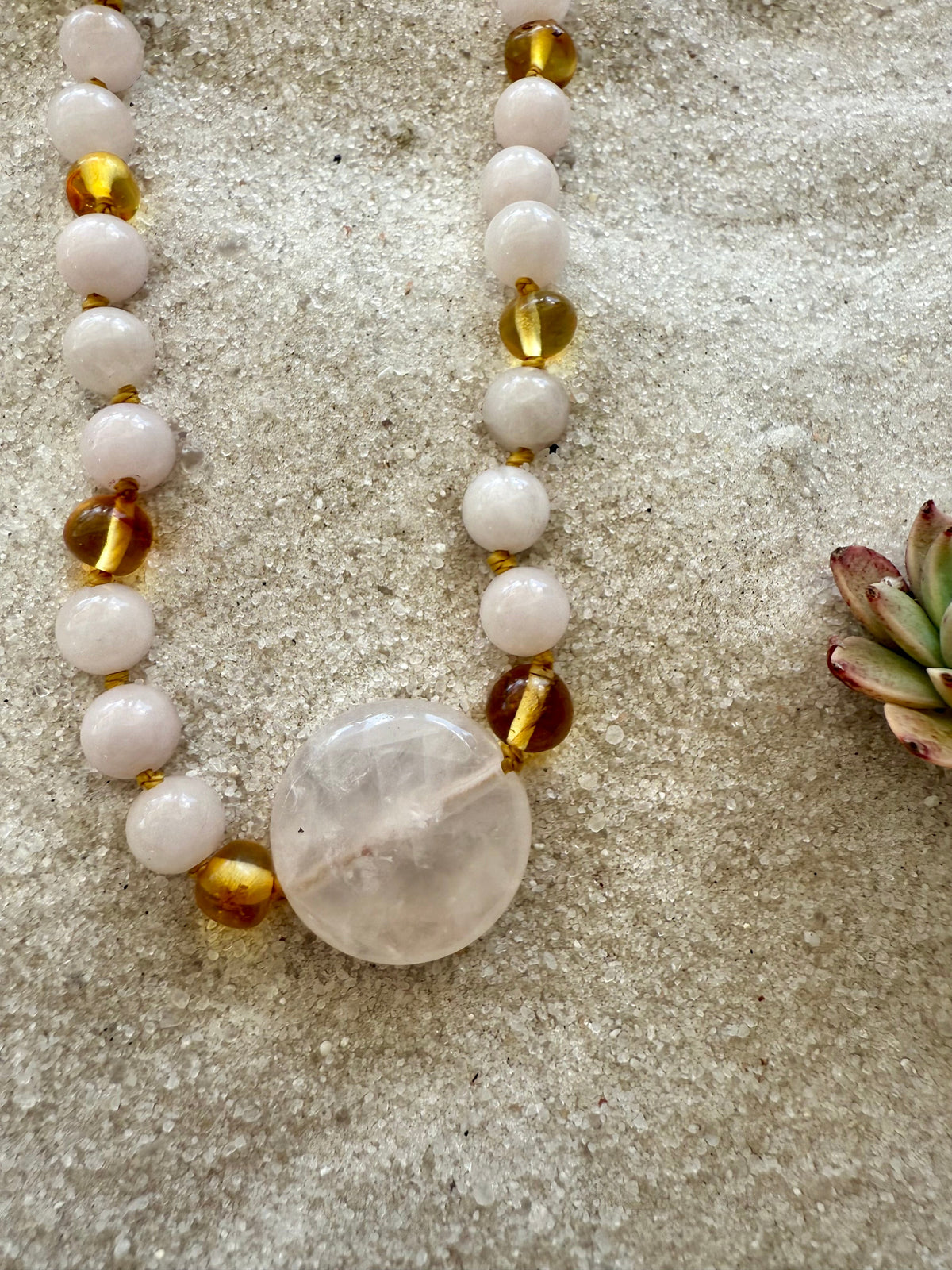 Stone bead necklace with pink rose quartz beads and gold amber accents, heart charm