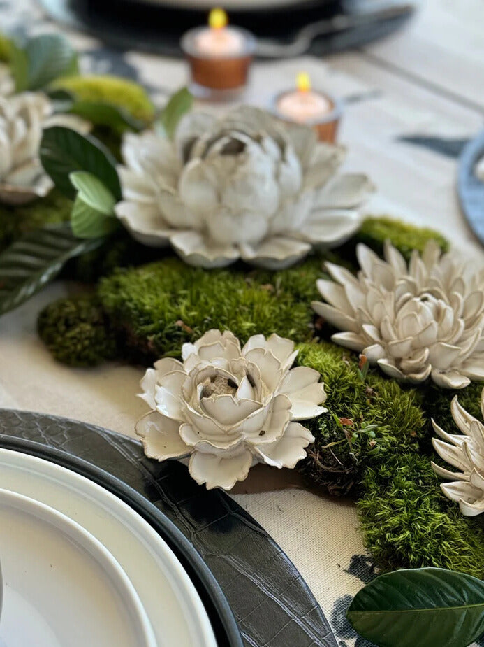 Ivory ceramic peony flowers on moss centerpiece with small candles