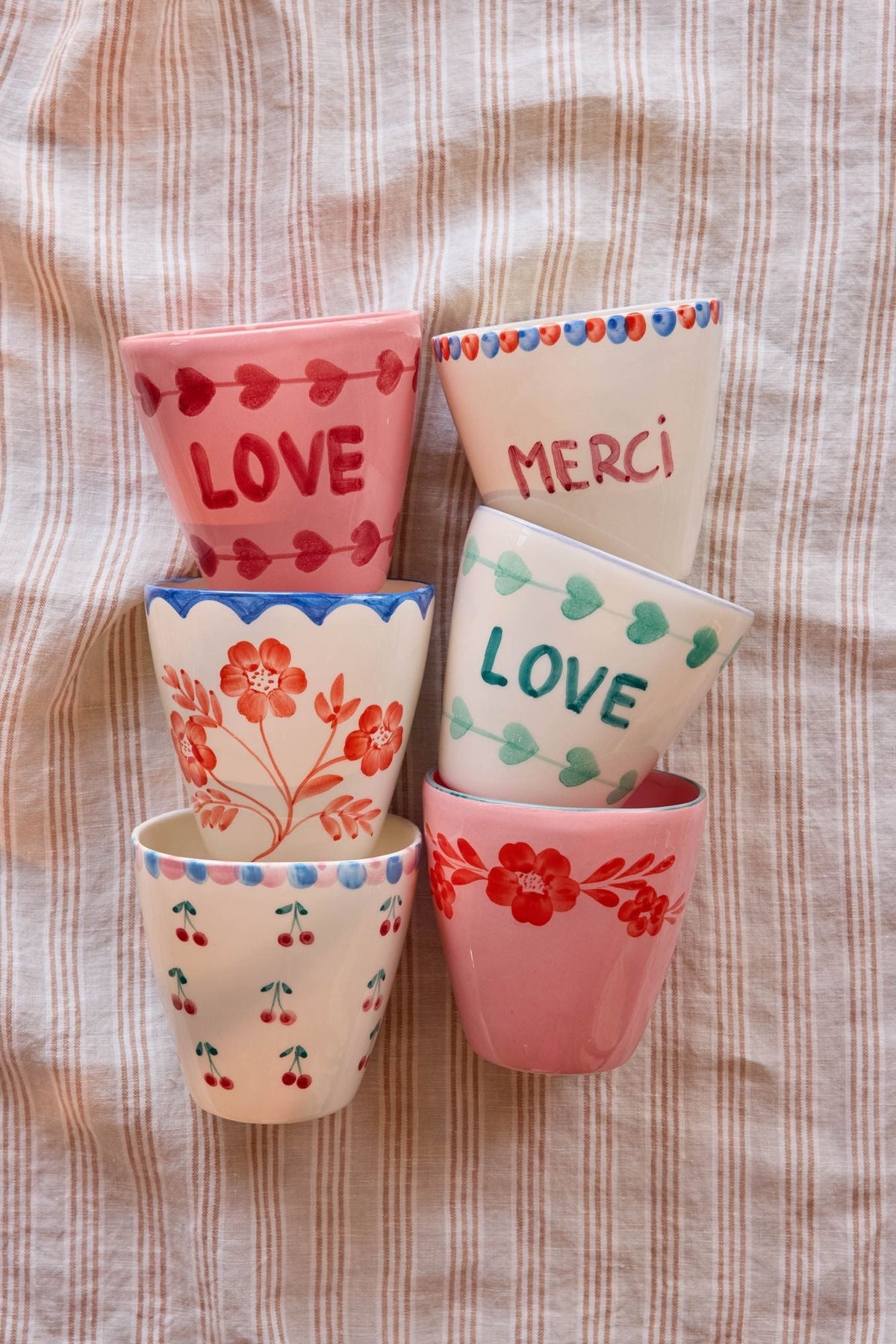 Ceramic oval cup with floral designs and text "LOVE" and "MERCI"