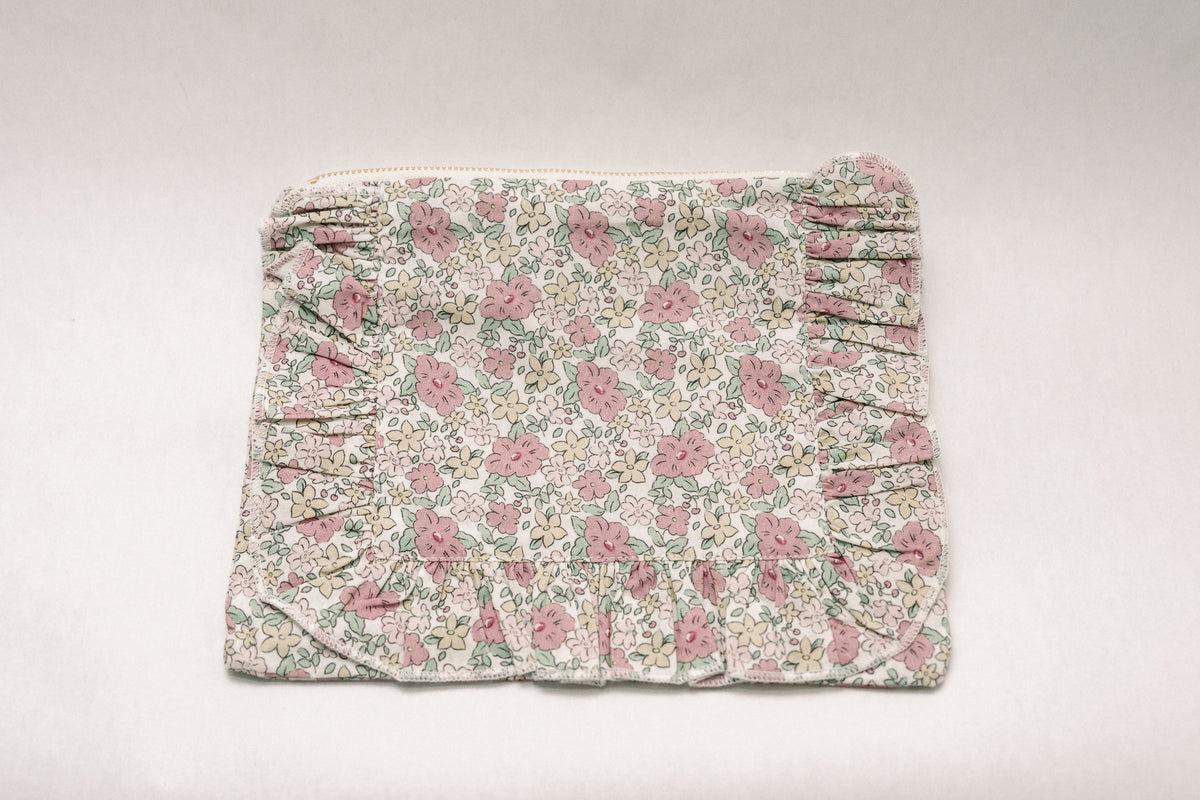 Rectangular floral zipper pouch with gathered ruffle trim along one side.