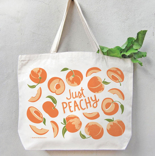 Peach-themed canvas tote bag with “Just Peachy” graphic on the front, open top