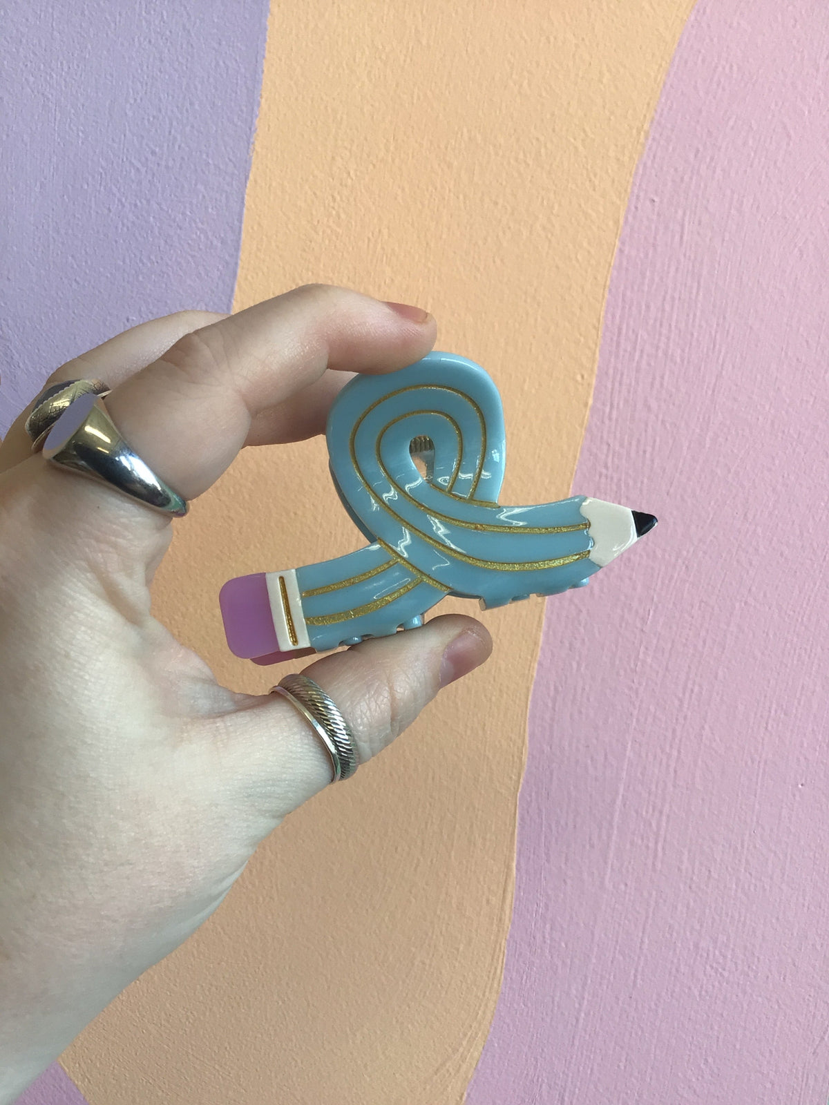 Blue cartoon-style hair claw with yellow stripes and pink accent.