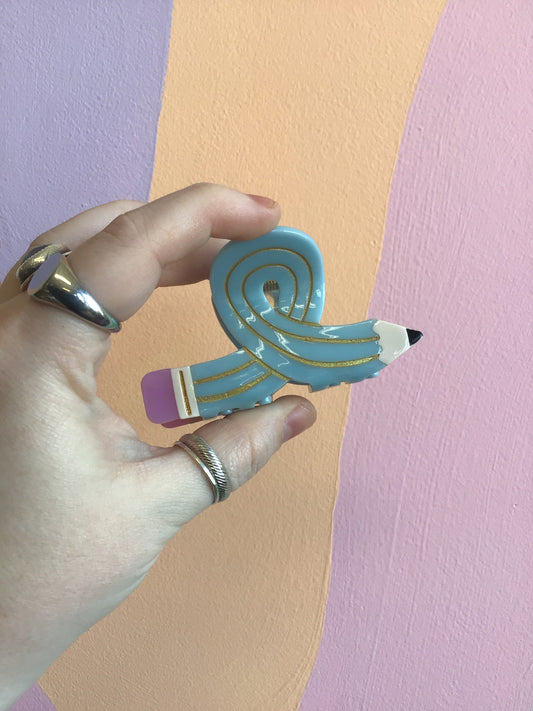 Blue cartoon-style hair claw with yellow stripes and pink accent.